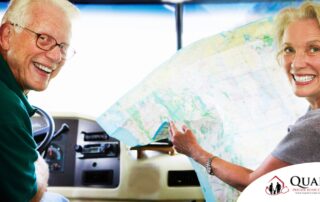 An older couple looks back smiling from the front of an RV, representing how day trips for seniors can help boost the mood of everyone.